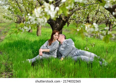A couple in love kissing lying under a flowering tree