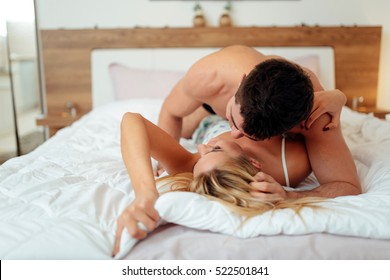 Couple In Love Lying On Bed And Touching Each Other Tenderly