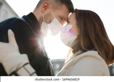 Couple in love, man and woman kissing each other in protective medical mask on face. Guy, girl against pandemic coronavirus, virus protection. Covid19