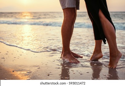 Couple in love on the sunrise sea side. Close up legs image - Powered by Shutterstock