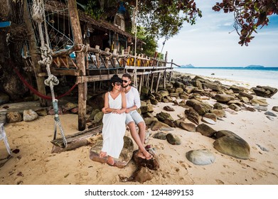 Couple in love on a swing by the sea. Couple in love on an island off the coast. Honeymoon. Couple by the sea. A guy and a girl travel to beautiful places. Honeymoon trip. Relax on the island