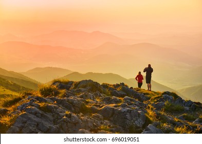 Couple in love on the top of the hill looking at sunset