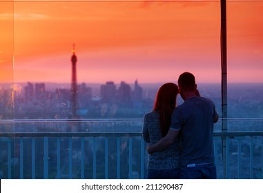 Couple In Love At Paris Admire Eiffel Tower At Sunset