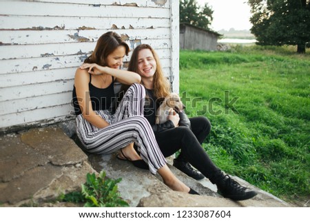 Couple in love resting in nature. Couple in love with a dog. A beautiful woman and a man sitting on a stone floor.