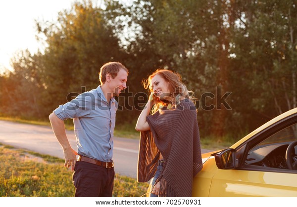Couple in love. Road\
Trip. The guy and the girl are standing by the car. They talk and\
rest from a long trip
