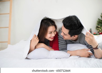 Couple In Love Sharing Genuine Emotions And Happiness Lying On Bed.