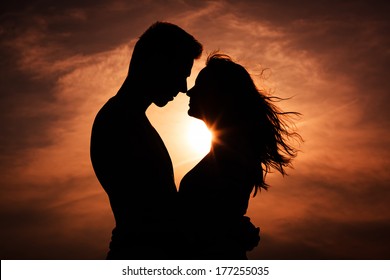 Couple in love silhouette during sunset - touching noses