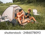 couple in love sit on the grass enjoy camp with coffee and talk