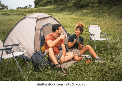 couple in love sit on the grass enjoy camp with coffee and talk - Powered by Shutterstock