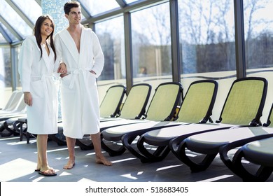 Couple in love standing next to a  pool in a  robe and relaxing