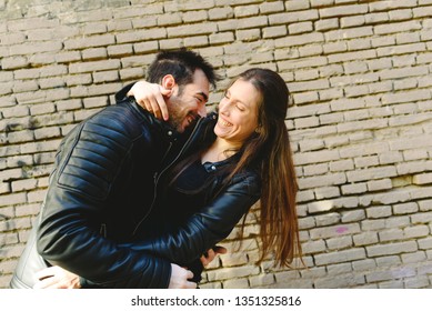 Couple In Love Tickling And Laughing Hard During A Casual Walk Through The City.