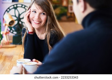couple in love together drink tea in cafe. breakfast or lunch together in vacation. focus on woman face in background - Shutterstock ID 2233253343