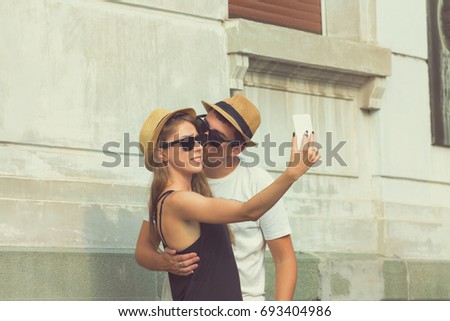Couple in love using cellphone outdoors.