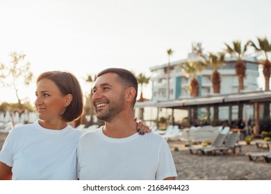 Couple In Love Walking On The Beach. Family. Diverse Couple On Summer Vacation.Portrait Beautiful Healthy Young Adults Girlfriend And Boyfriend Hugging Happy.