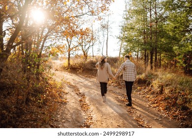 Couple in love are walking outdoor and enjoying the autumn weather in the forest. Concept of vacation, weekend, love. - Powered by Shutterstock