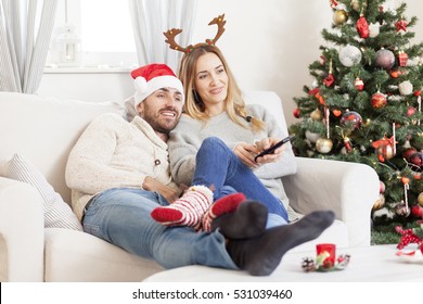 Couple In Love Watching TV At Christmas Eve