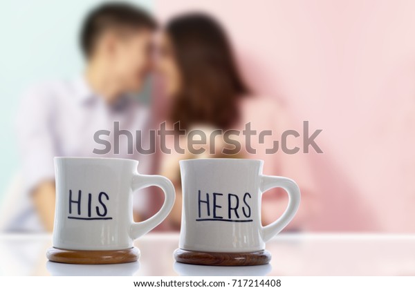 Couple lover blurry in background with two\
coffee cups \