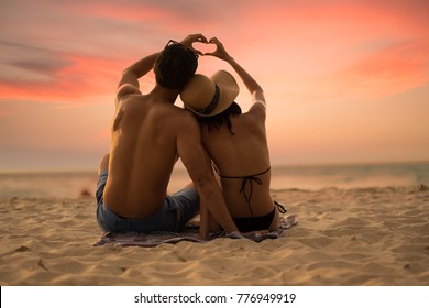 Couple lover make hand lover on the sunset beach