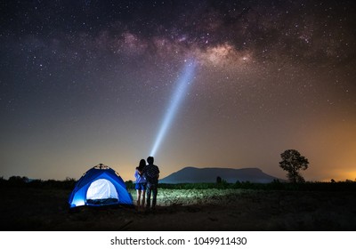 Couple Lover Standing Near The Tent And Looking Milky Way And Stars On The Sky At Night.silhouette Style.this Picture May Have Some Noise.