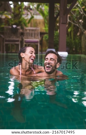 Couple of lovers in a beautiful villa with swimming pool in a tropical climate location - Happy people on a summer vacation, influencers enjoying a luxury resort