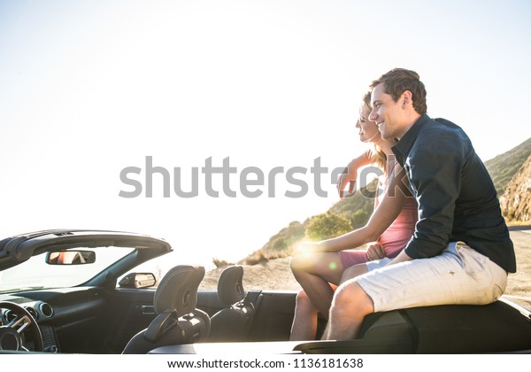 Couple of lovers driving on a convertible\
car - Newlywed pair on a romantic\
date