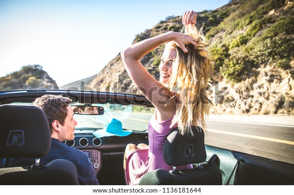Couple of lovers driving on a convertible\
car - Newlywed pair on a romantic\
date