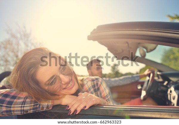Couple of lovers driving on a convertible
car - Newlywed pair on a romantic
date