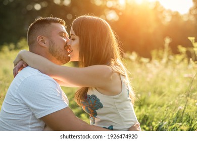 Couple lovers hugging and kissing in the park at sunset. Love, youth, happiness concept. - Powered by Shutterstock