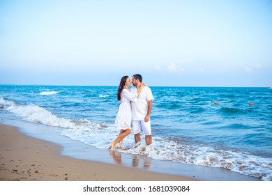 Couple of lovers just married, honeymoon. Elegant and attractive happy family man and woman walking at sea coast. Young wife and husband in love - Powered by Shutterstock