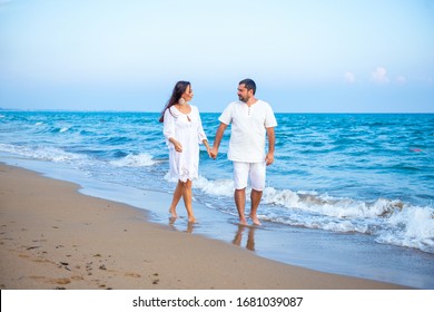 Couple of lovers just married, honeymoon. Elegant and attractive happy family man and woman walking at sea coast. Young wife and husband in love - Powered by Shutterstock