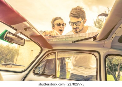 Couple Of Lovers Looking At A Map During Honeymoon Trip Vacation - Vintage Lifestyle Traveling Around The World With Old Retro Classic Car - Young People Enjoying Together Happy Moments Of Life