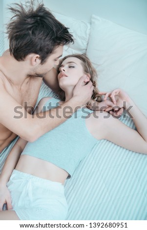 Similar – Young couple in love embracing lying over a bed