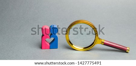 Couple of lovers standing near a magnifying glass. The concept of finding love and dating through the Internet. Search for the second half. Social networks and dating sites. Find your soul mate