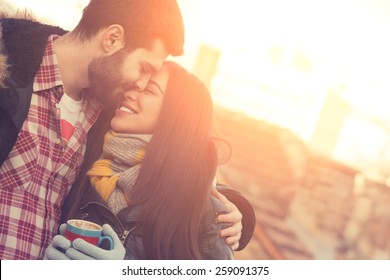 Couple loving each other outdoors on a coffee break.
