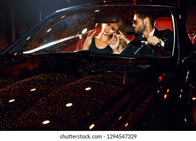 Couple In Luxury Car. Night Life.