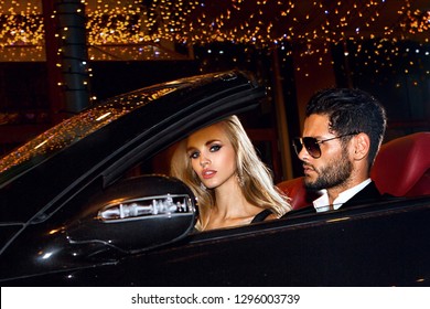 Couple In Luxury Car. Night Life.