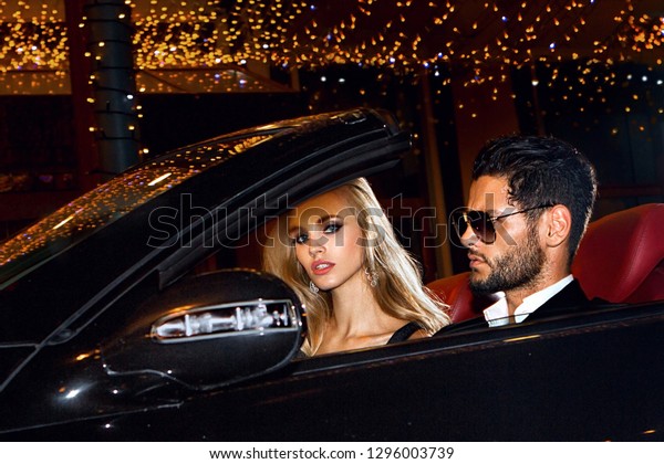 Couple in luxury car. Night\
life.
