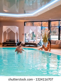 Couple At Luxury Indoor Pool, Men And Woman At Swiming Pool In Spa
