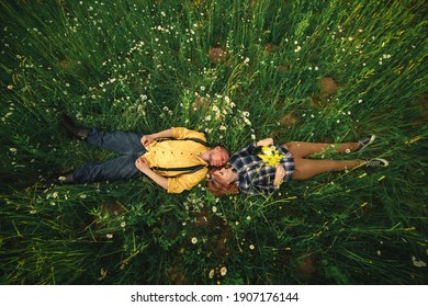 couple lying in a field of flowers. Happy couple lie in a flower. Romance, emotional and love scene