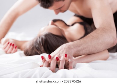 Couple lying on bed having erotic moment