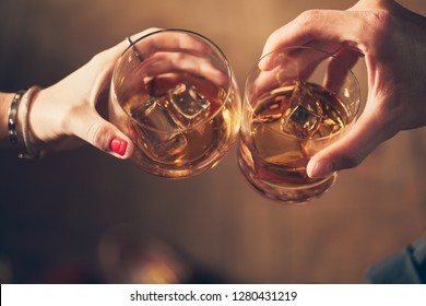 A Couple Makes A Toast With Whiskey