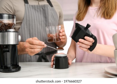 Couple Making Coffee Together In Kitchen, Man Putting Ground Beans Into Moka Pot