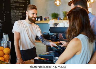 Couple Making Payment With Smartphone At Coffe Shop