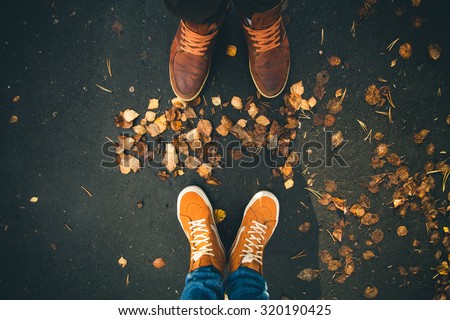 Couple Man and Woman Feet in Love Romantic Outdoor with Autumn leaves on background Lifestyle Fashion concept 