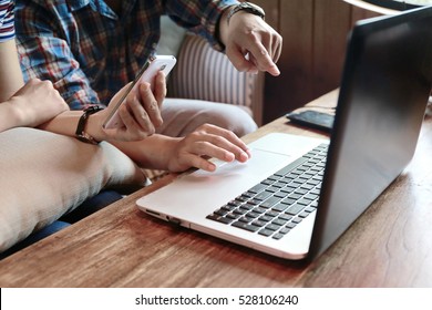 Couple Man And Woman Hand Using Laptop And Phone Together On Wooden Table.