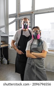 Couple Man And Woman In Pink Respirators In A Workshop. Respiratory Protection. Vertical Image.