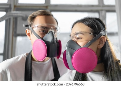 Couple Man And Woman In Pink Respirators In  Workshop. Respiratory Protection.