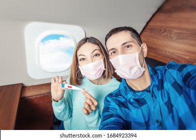 A Couple Of Man And Woman Wearing Medical Masks And Respirators Travel In The First Class Of An Airplane During An Outbreak Of The Coronavirus And Flu Pandemic