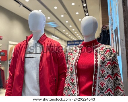 A couple of mannequins are positioned next to each other, showcasing clothing or accessories in a store display. These human-like figures are often used to model outfits for retail purposes.