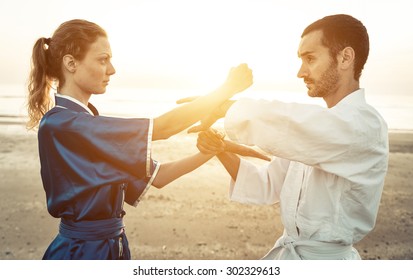 couple of martial artists training on the beach at sunrise  - Powered by Shutterstock